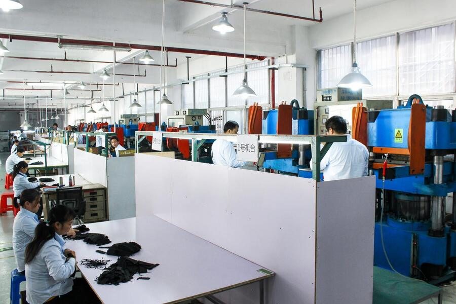 The assembly and finishing hall, staff working at benches with machines along the wall.